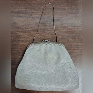 Like New-Sparkly silver clutch purse. Has a metal frame and kiss lock closure.